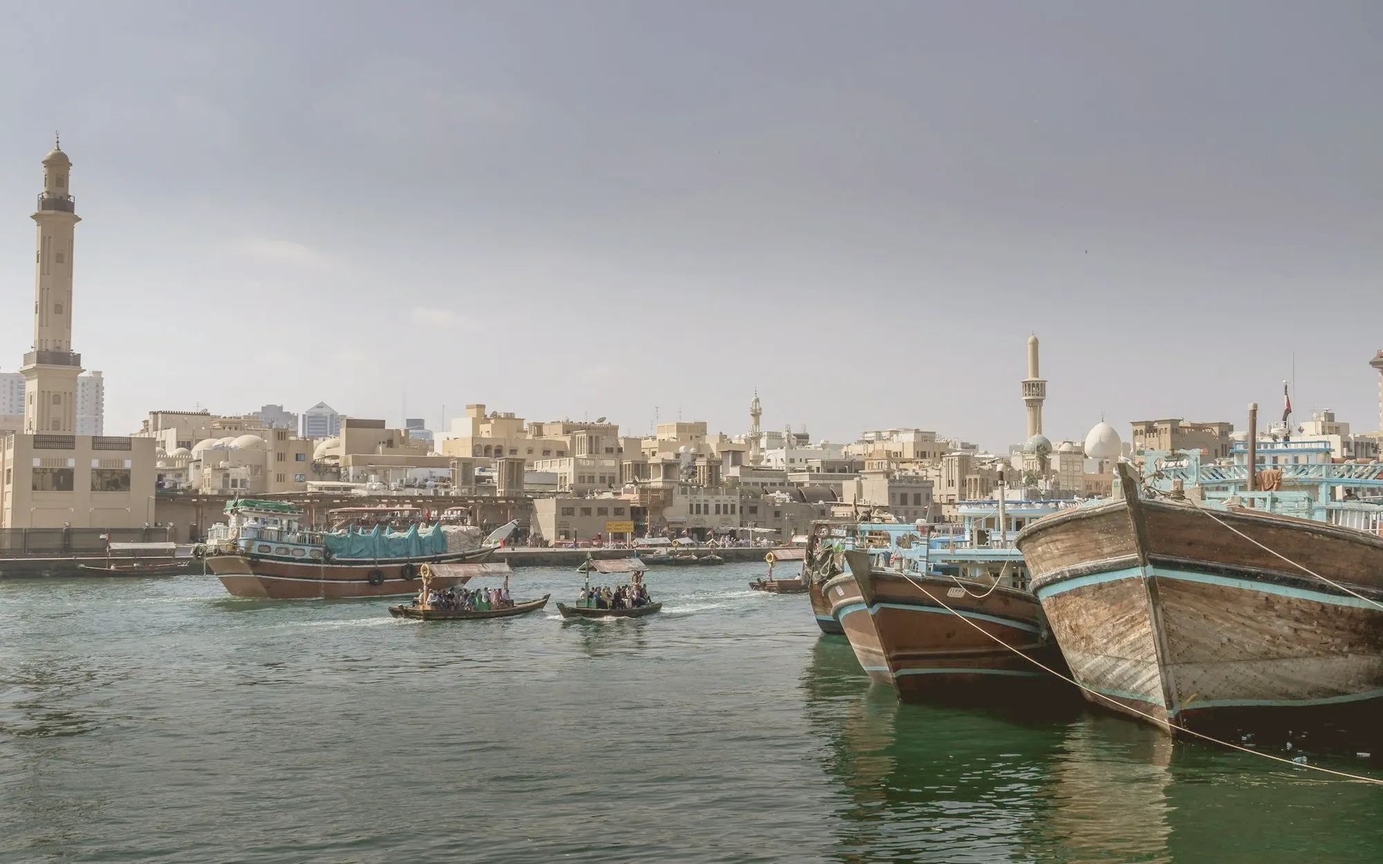 Traditional wooden dhows moored on Dubai Creek with Deira behind