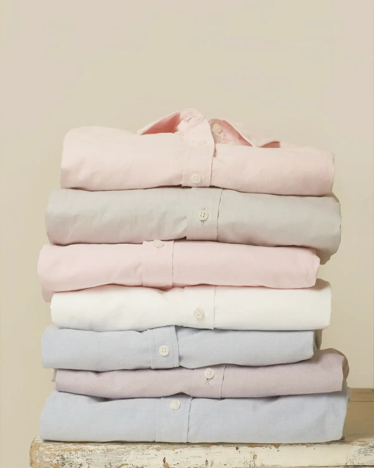 Stack of folded cotton shirts in soft pastel colours